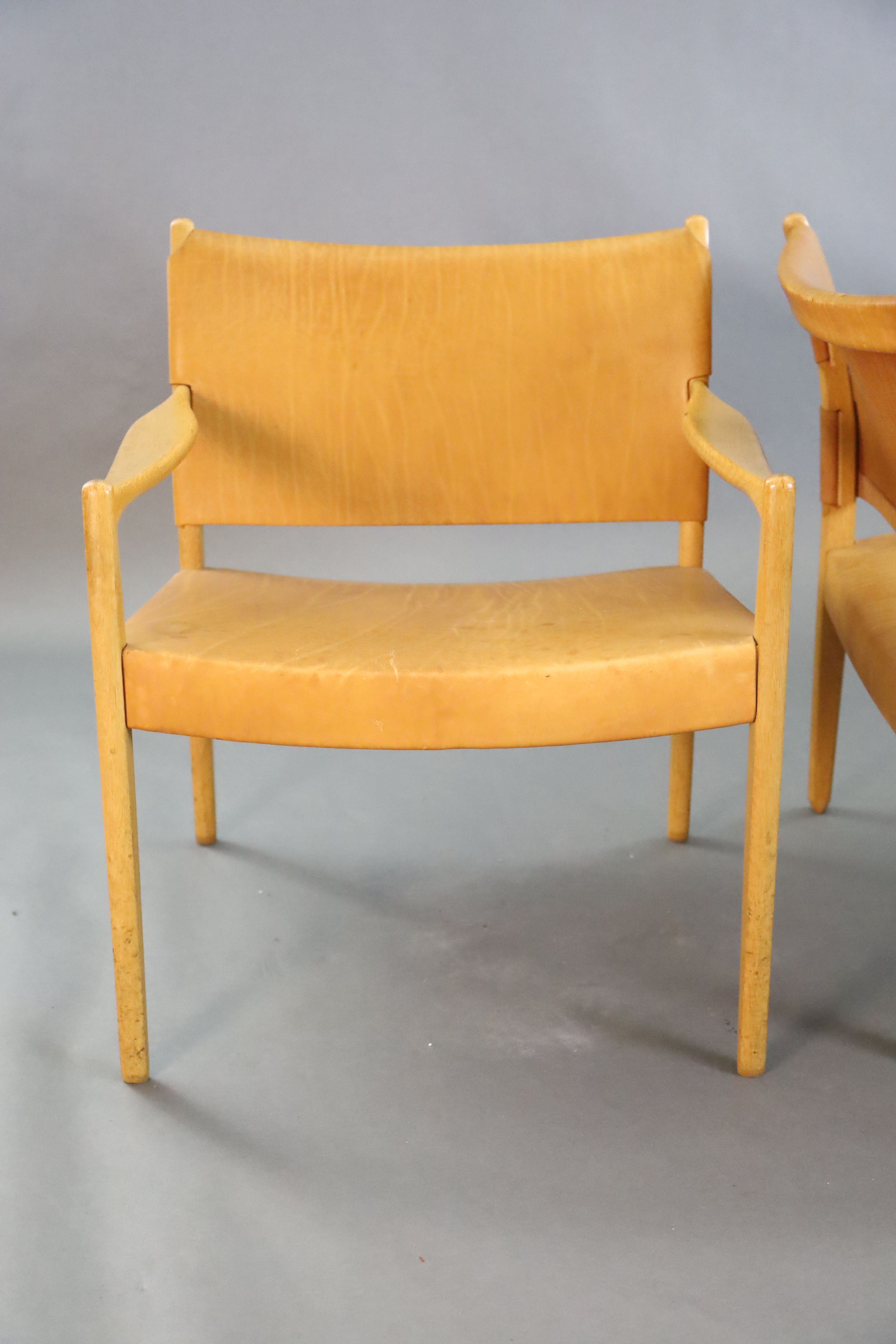 A pair of Swedish Varufakta tan leather and golden oak armchairs, W.2ft 1in. D. 2ft 1in. H.2ft 4in.